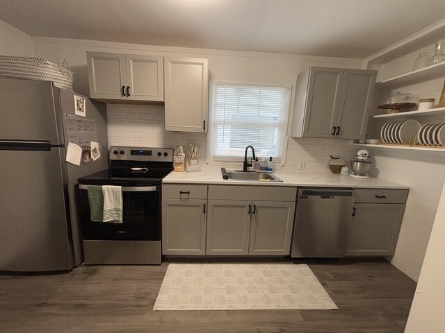 kitchen featuring appliances with stainless steel finishes, sink, backsplash, dark hardwood / wood-style floors, and gray cabinetry