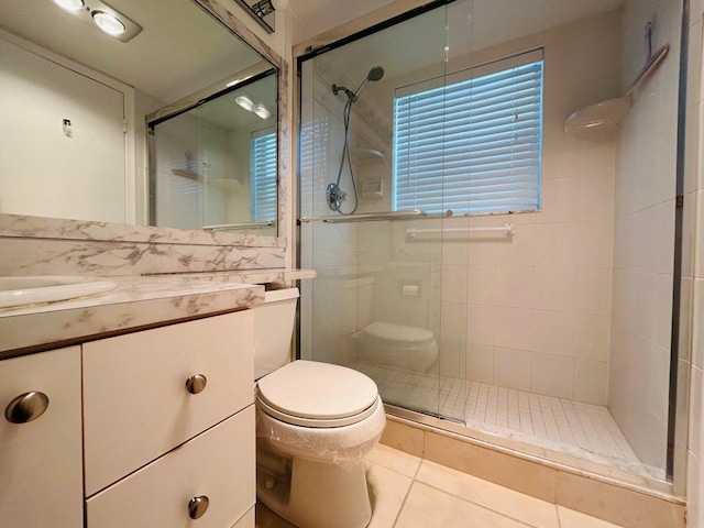 bathroom featuring tile patterned flooring, vanity, toilet, and an enclosed shower