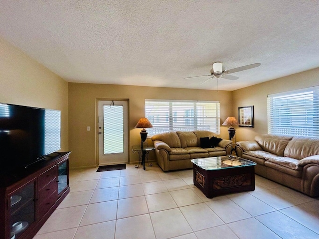 tiled living room featuring ceiling fan and a textured ceiling