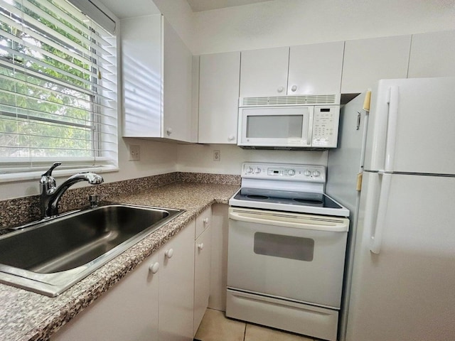 kitchen with white cabinetry, white appliances, sink, and light tile patterned floors