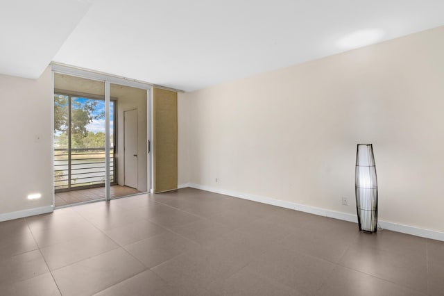 tiled spare room with a wall of windows