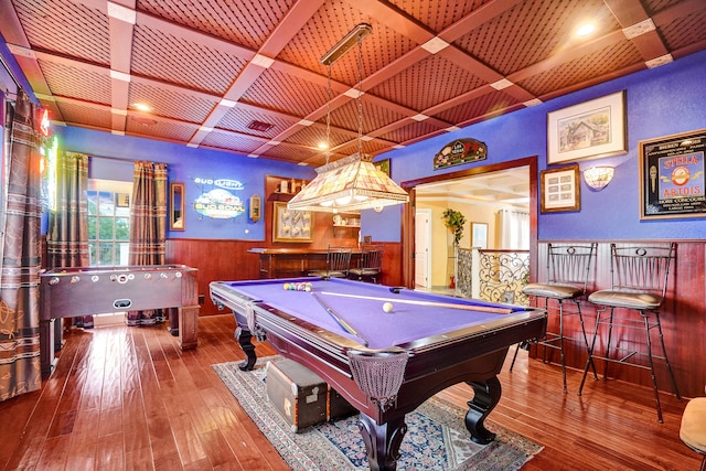 game room with coffered ceiling, hardwood / wood-style flooring, and indoor bar