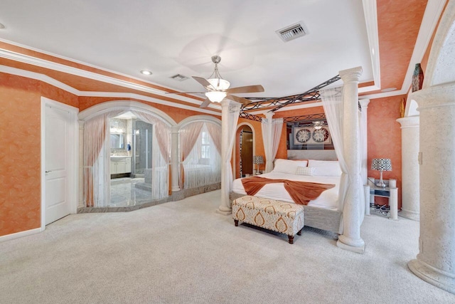 carpeted bedroom with a raised ceiling, ceiling fan, decorative columns, and ornamental molding