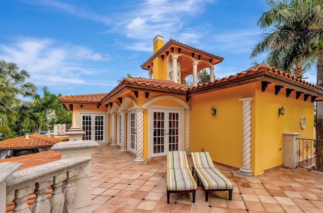 rear view of house with a patio area and french doors