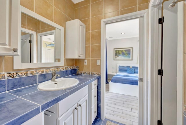 bathroom featuring tile walls, vanity, and backsplash