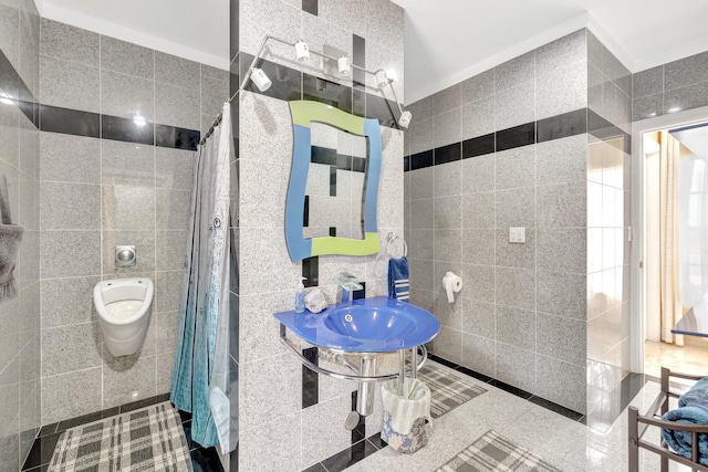 bathroom with tile walls, sink, toilet, and walk in shower