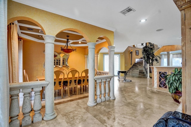 interior space with crown molding, plenty of natural light, and ornate columns