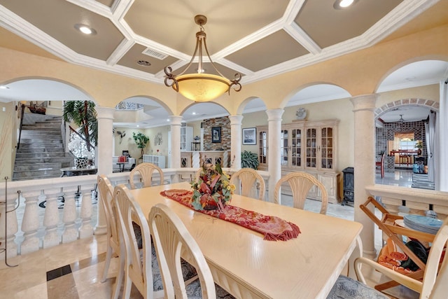 dining area featuring a towering ceiling, crown molding, decorative columns, and coffered ceiling