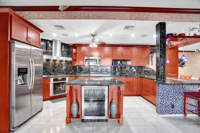 kitchen with appliances with stainless steel finishes, backsplash, beverage cooler, dark stone counters, and wall chimney range hood