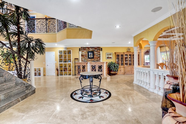 entrance foyer featuring decorative columns and ornamental molding