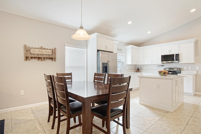 dining space featuring lofted ceiling, sink, and light tile patterned floors