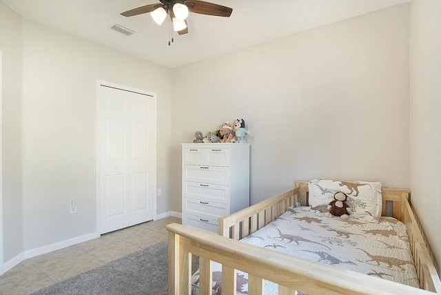 bedroom featuring ceiling fan, light tile patterned floors, and a closet