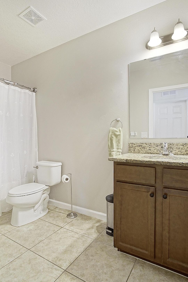 bathroom featuring tile patterned flooring, vanity, a textured ceiling, and toilet