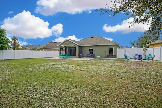 rear view of house with a patio and a lawn