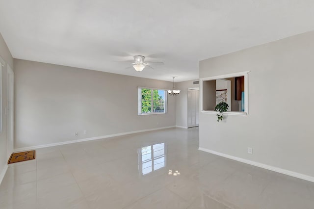 unfurnished room featuring ceiling fan with notable chandelier