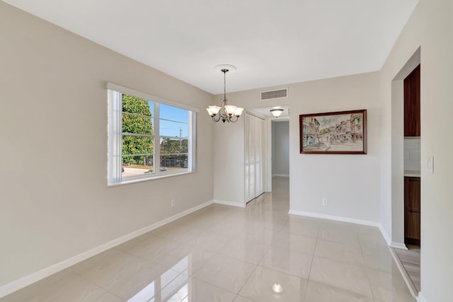 empty room featuring light tile patterned floors and a notable chandelier