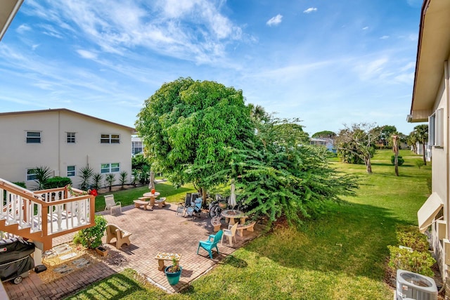 view of yard with central AC unit and a patio