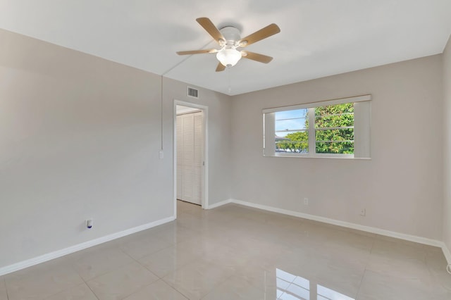 spare room with ceiling fan and light tile patterned flooring