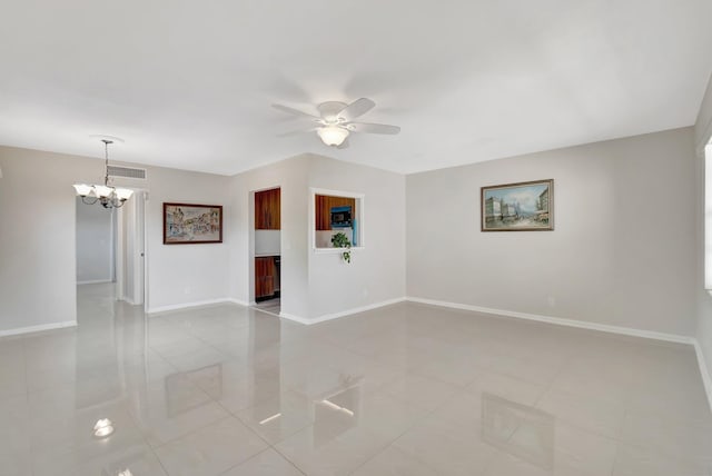 spare room featuring ceiling fan with notable chandelier and light tile patterned floors