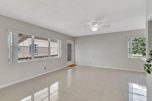 unfurnished room with ceiling fan and light tile patterned floors