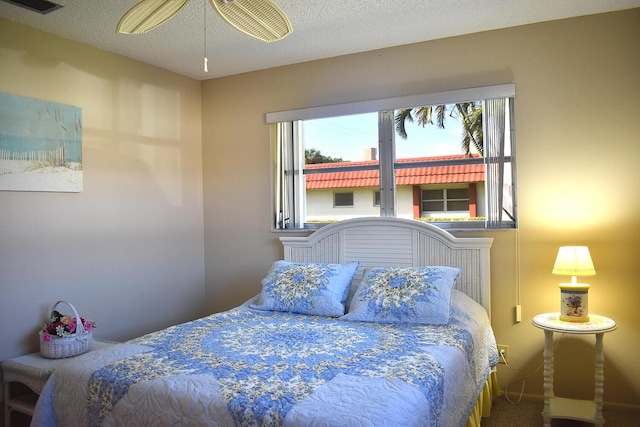 bedroom with carpet flooring, ceiling fan, and a textured ceiling