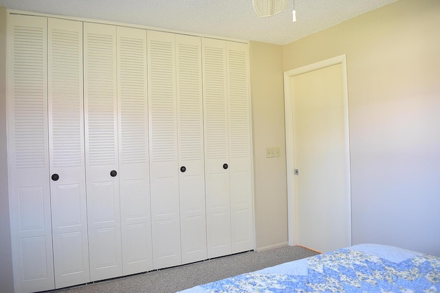 bedroom with carpet flooring, a textured ceiling, and a closet