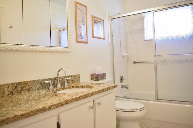 full bathroom with tile patterned floors, vanity, toilet, and bath / shower combo with glass door