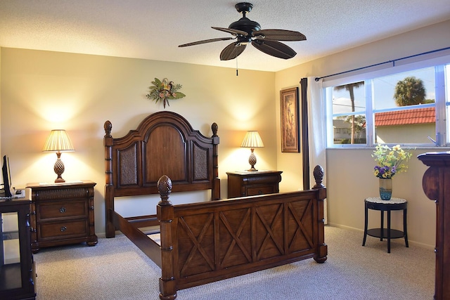 bedroom featuring light carpet, a textured ceiling, and ceiling fan