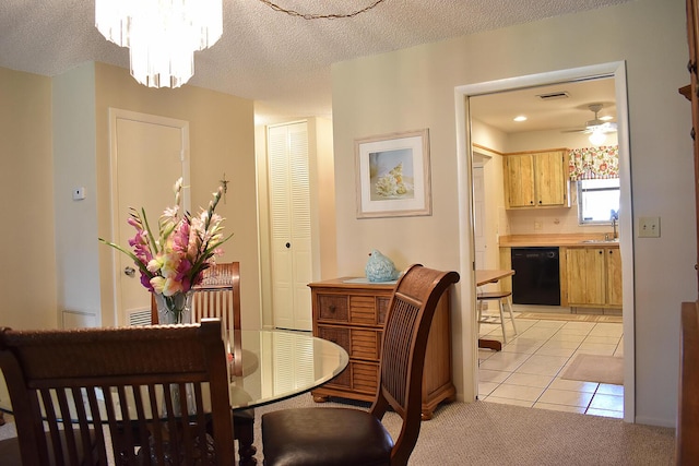 tiled dining area featuring ceiling fan with notable chandelier, a textured ceiling, and sink