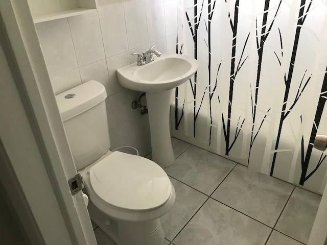 bathroom with sink, tile patterned flooring, toilet, tile walls, and tasteful backsplash