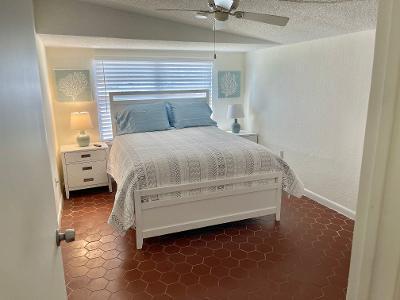 bedroom with vaulted ceiling, ceiling fan, and a textured ceiling