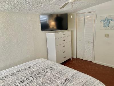 bedroom with ceiling fan, lofted ceiling, a textured ceiling, and a closet