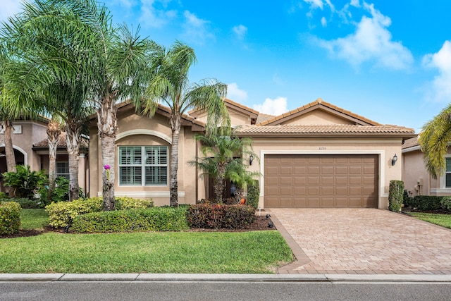 mediterranean / spanish-style house featuring a front yard and a garage