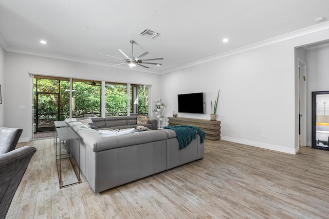 living room featuring ceiling fan, light hardwood / wood-style floors, ornamental molding, and a textured ceiling