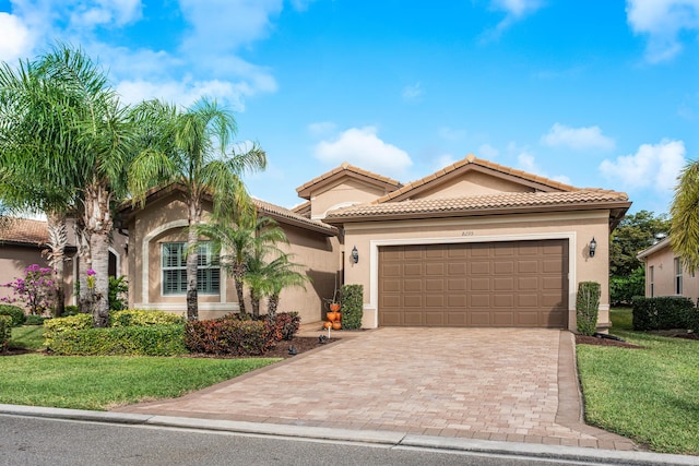 mediterranean / spanish-style home featuring a garage and a front lawn