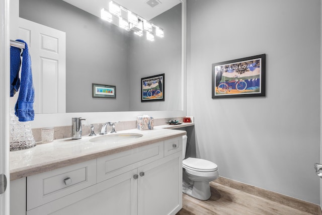 bathroom featuring hardwood / wood-style flooring, vanity, and toilet