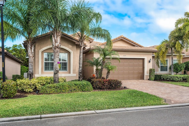 mediterranean / spanish-style home featuring a garage and a front lawn