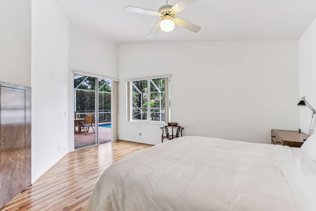 bedroom with access to exterior, ceiling fan, light hardwood / wood-style flooring, and high vaulted ceiling