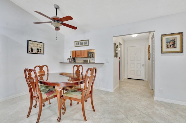 tiled dining space featuring ceiling fan and lofted ceiling