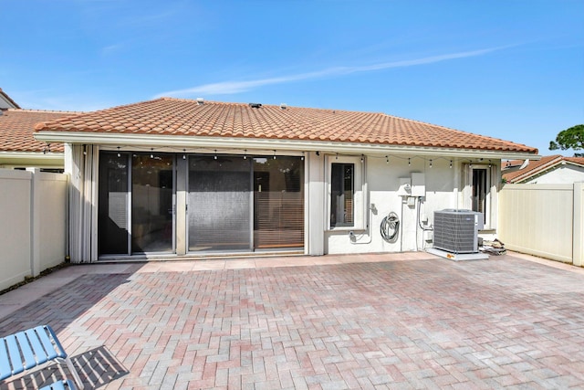 rear view of house with central AC unit and a patio area