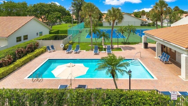 view of swimming pool with tennis court