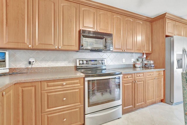 kitchen featuring backsplash, light tile patterned floors, and appliances with stainless steel finishes