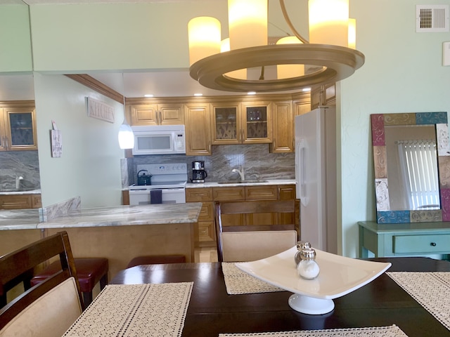 kitchen with white appliances, backsplash, ornamental molding, and sink