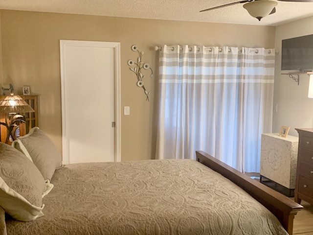 bedroom with ceiling fan and a textured ceiling