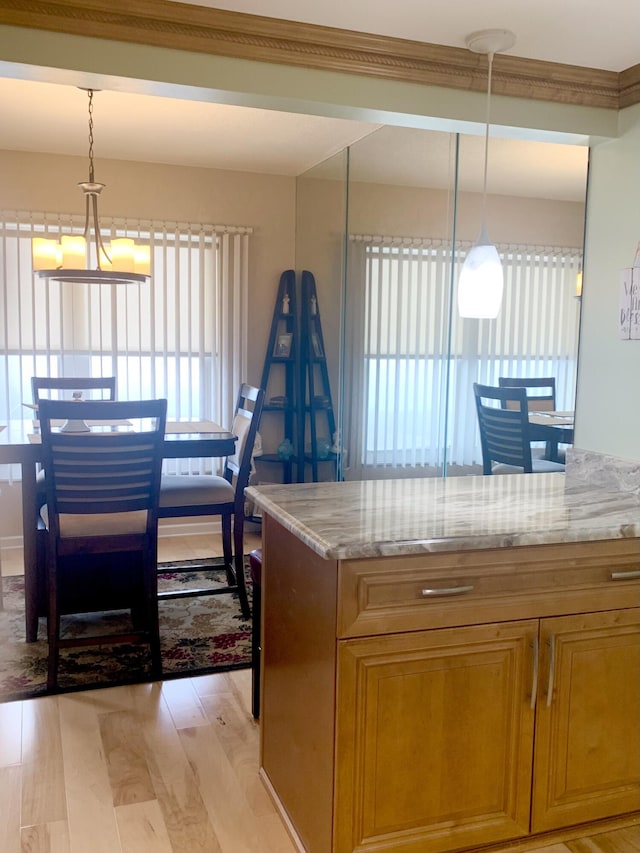 kitchen with a wealth of natural light, pendant lighting, and light wood-type flooring