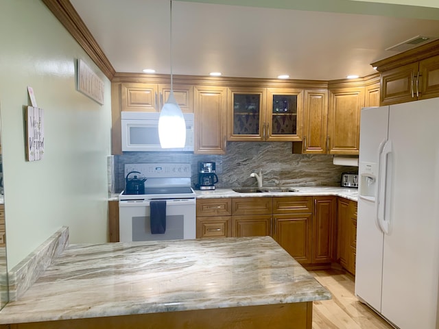 kitchen with white appliances, sink, hanging light fixtures, light hardwood / wood-style flooring, and decorative backsplash