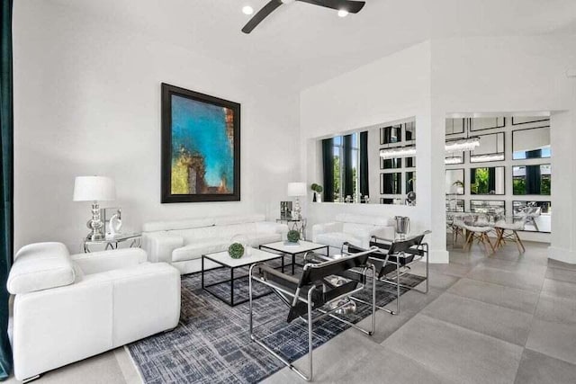 living room featuring ceiling fan and a towering ceiling