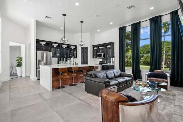 living room with recessed lighting, visible vents, and a textured ceiling