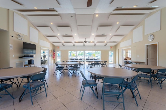 tiled dining space featuring ceiling fan and a high ceiling