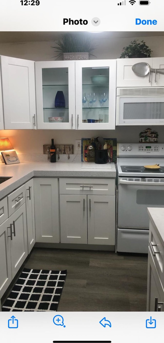 kitchen featuring sink, dark hardwood / wood-style floors, white cabinetry, and electric stove